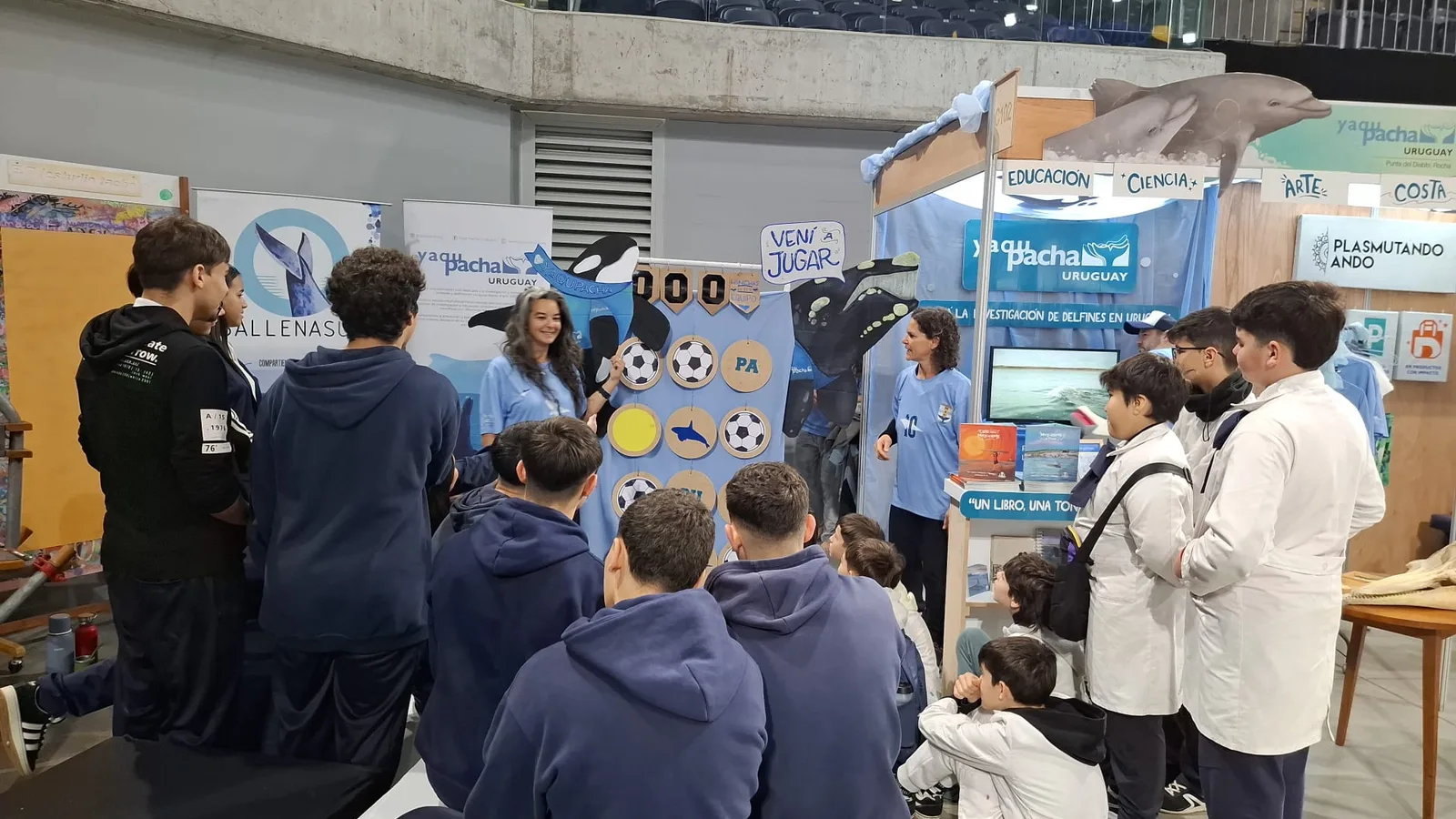Grupo de estudiantes participando del juego educativo en el stand de Yaqu Pacha Uruguay